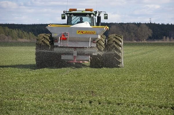 John Deere 8530 tractor with Bredal TX3500 spreader, spreading granular fertilizer on arable field, Tierp