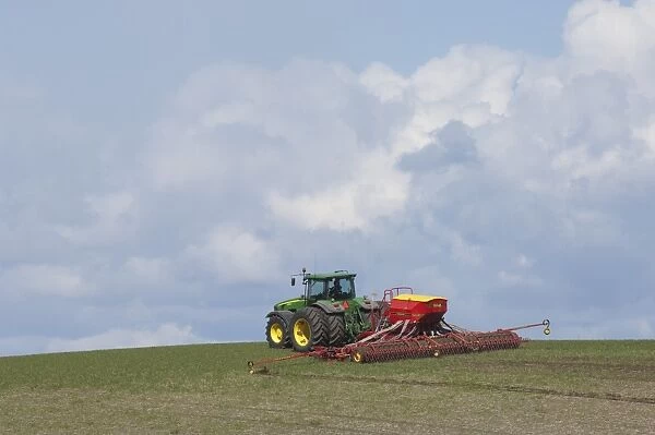 John Deere 8530 tractor with Vaderstad seed drill, sowing seed in field, Skane, Sweden, spring