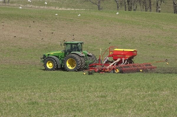 John Deere 8530 tractor with Vaderstad seed drill, sowing seed in field, Skane, Sweden, spring