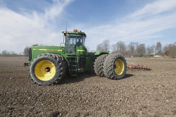 John Deere 9400 tractor with harrows, harrowing arable field, Tierp, Uppsala, Sweden, may