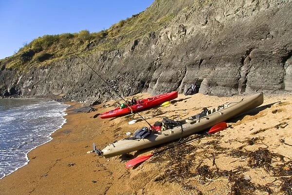Kayaks with fishing rods, pulled up on beach, Chapmans Pool, Dorset, England, november