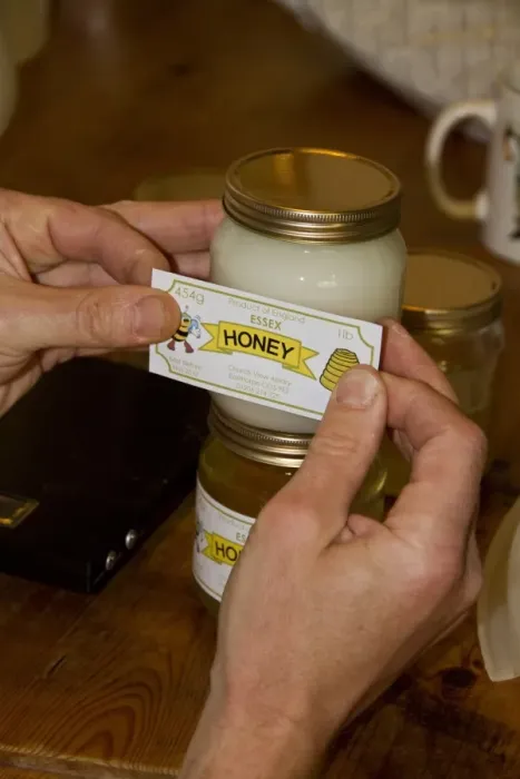 Framed Print : Labelling up a pot of Borage Honey, this has a white colour
