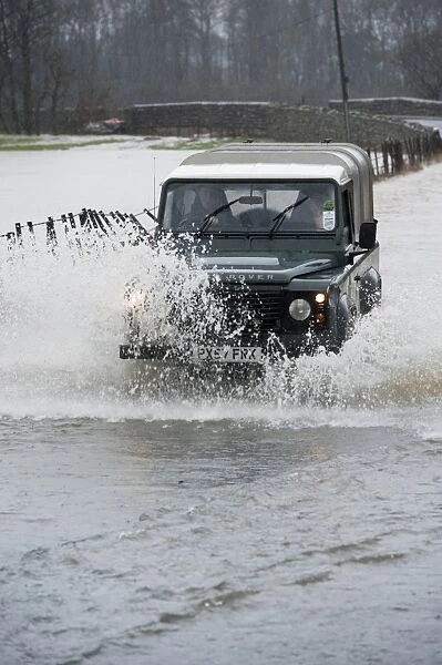 Land Rover driving through flooded road, Cumbria, England, December