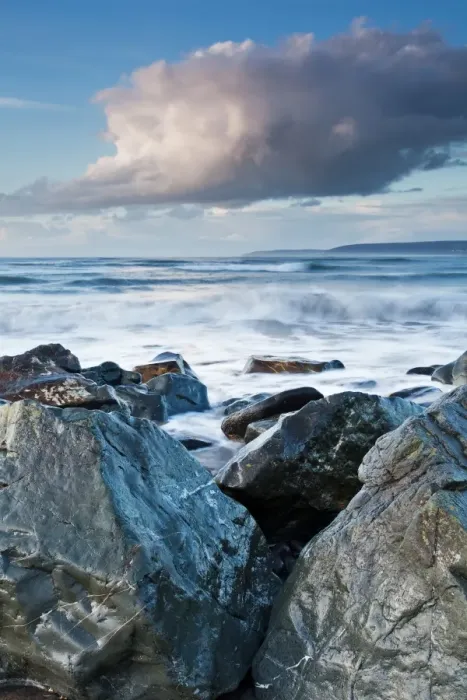 Framed Print : Large boulders of sea defences at bottom of pebble ridge with waves from incoming tide Framed Print : Large boulders of sea defences at bottom of pebble ridge with waves from incoming tide