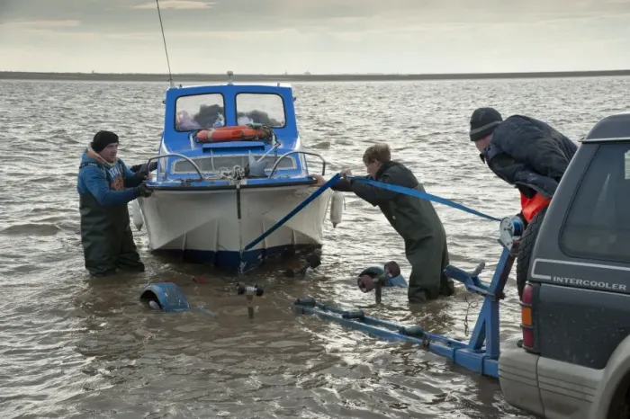 Framed Print : Licensed cockle pickers landing boat and unloading after picking from cockle beds, Foulnaze Bank, between Lytham and Southport, Ribble Estuary, Lancashire, England, november