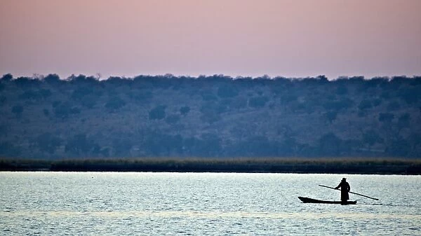 Makoro canoe silhouetted at sunset, Chobe N. P. Botswana, July