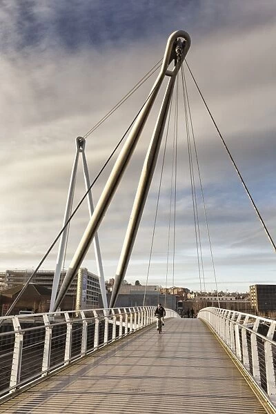 Man on bicycle crossing footbridge over river, Newport City Footbridge, River Usk, Newport, South Wales, Wales, january