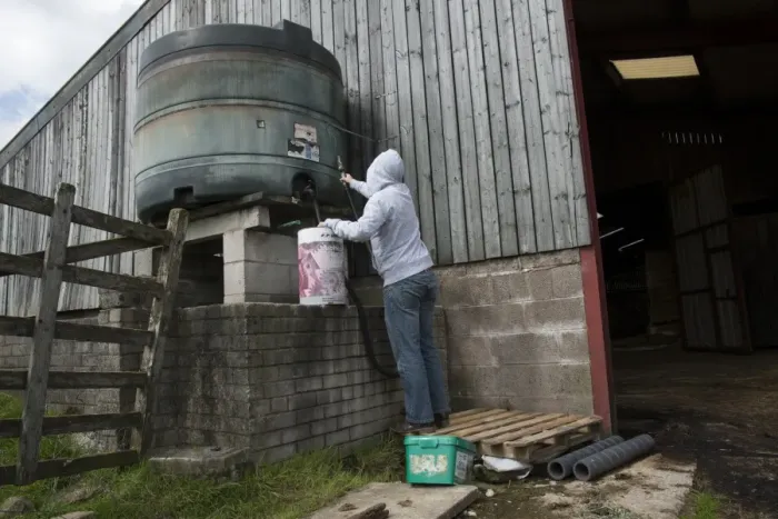 Framed Print : Man wearing hoodie, about to steal diesel from tank in farmyard, Lancashire, England, August Framed Print : Man wearing hoodie, about to steal diesel from tank in farmyard, Lancashire, England, August