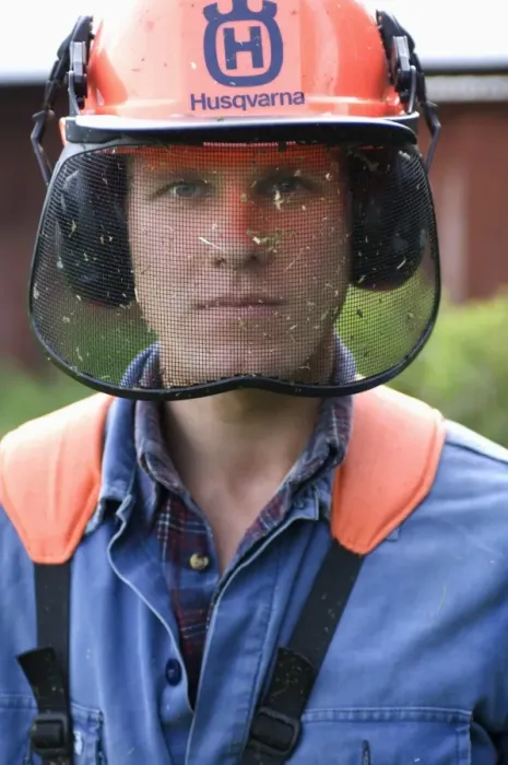 Framed Print : Man wearing protective helmet with visor and ear defenders, using strimmer on farm, Sweden