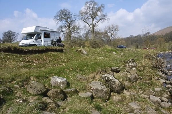 Motorhome and cars parked near riverbank, River Wharfe, Bolton Abbey, North Yorkshire, England, march