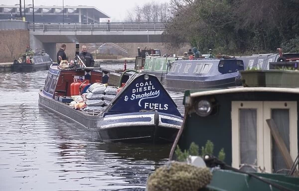 Narrowboat carrying load of fuel on city canal, Regents Canal, Islington, London, England, March