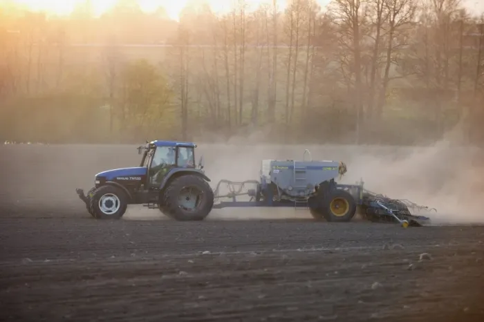 Framed Print : New Holland TM135 tractor with Overum seed drill, with wind blown dust in field at sunset, Uppland, Sweden, may