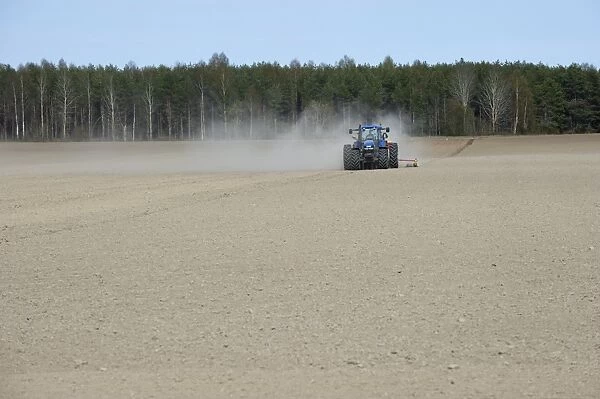 New Holland TM150 tractor, drilling in field with wind blown dust, Sweden, may