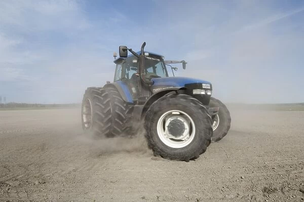 New Holland TM150 tractor, drilling in field with wind blown dust, Sweden, may