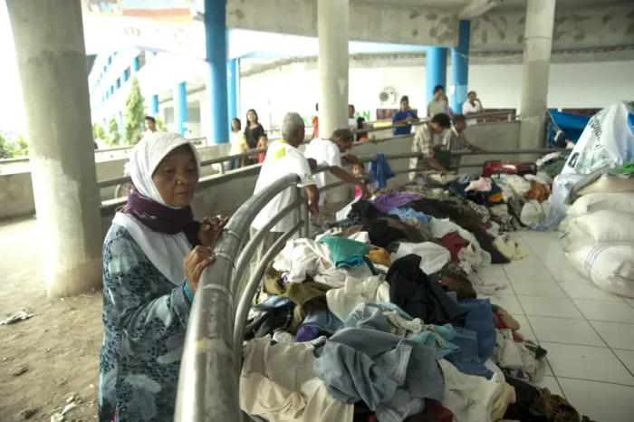 Framed Print : Old woman looking at clothes for refugees from recent volcanic eruption, Maguwo, Mount Merapi, Central Java, Indonesia Framed Print : Old woman looking at clothes for refugees from recent volcanic eruption, Maguwo, Mount Merapi, Central Java, Indonesia