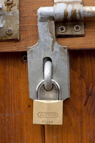 Padlock and bolt on wooden door of barn, Cumbria, England, august
