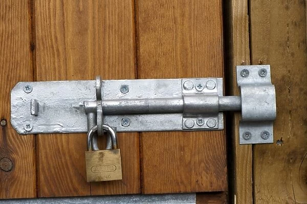 Padlock and bolt on wooden door of barn, Cumbria, England, august