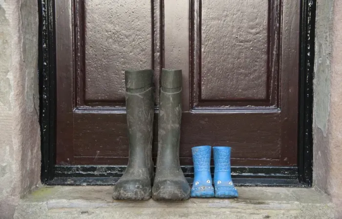 Framed Print : Two pairs of wellington boots, one childrens pair and one mens pair, outside farmhouse door, Whitewell, Lancashire