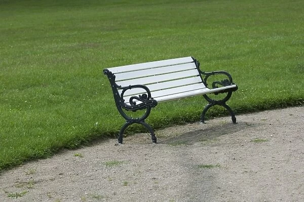 Park bench at edge of lawn, Sweden, june
