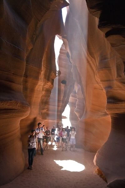 People caught in Light beam in Upper Antelope Canyon was formed by erosion of Navajo Sandstone