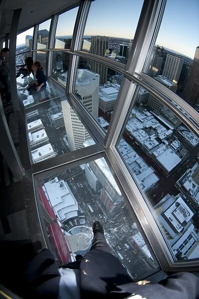 People sitting and standing on glass floor of observation tower, Calgary Tower, Calgary, Alberta, Canada