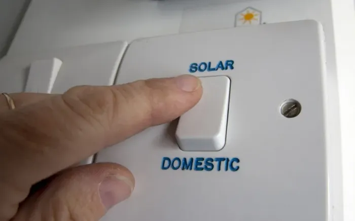 Framed Print : Person turning on solar power switch, England