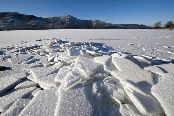 Piles of ice on shore of frozen lake, Derwent Water, Lake District, Cumbria, England, december 2010