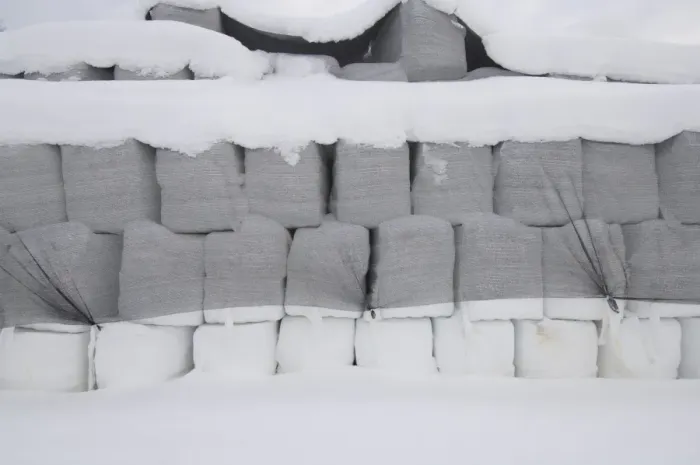 Framed Print : Plastic wrapped round silage bales, stacked under netting in snow, Sweden, winter Framed Print : Plastic wrapped round silage bales, stacked under netting in snow, Sweden, winter