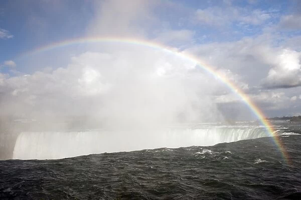 Rainbow forming in spray over waterfall, Horseshoe Falls, Niagara Falls, Niagara River, Ontario, Canada, august