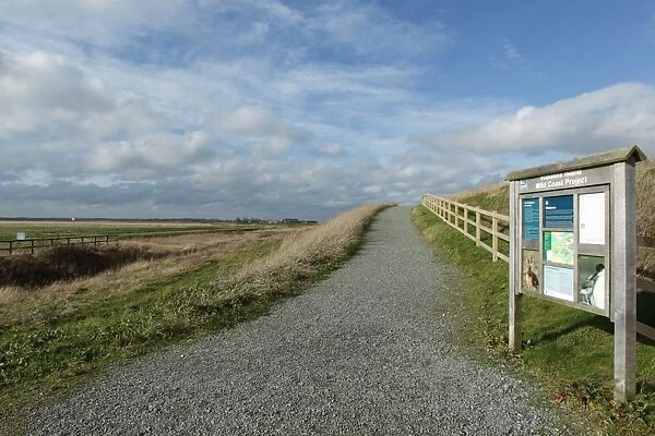 Reserve entrance sign and path in estuary marshland, reclaimed saltmarsh in managed retreat scheme