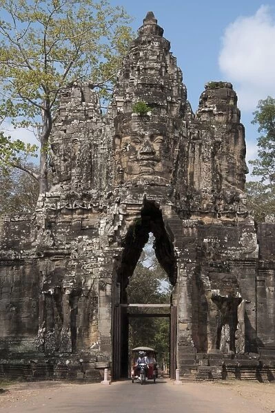 Rickshaw going through gate tower at Khmer temple, South Gate, Angkor Thom, Siem Riep, Cambodia