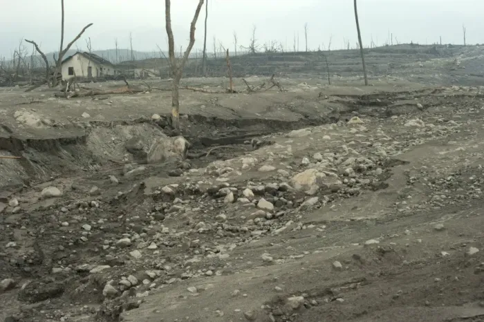 Framed Print : Riverbed and field covered in ash, damaged houses and dead trees, from recent volcanic eruption, Kepuharjo
