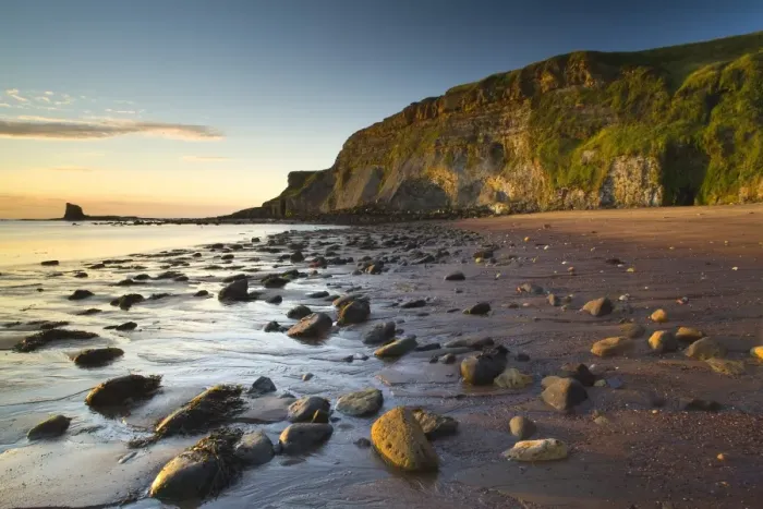 Framed Print : Rocks on sandy beach with sea cliffs at sunrise, Black Nab, Saltwick Bay, North Yorkshire, England, august Framed Print : Rocks on sandy beach with sea cliffs at sunrise, Black Nab, Saltwick Bay, North Yorkshire, England, august