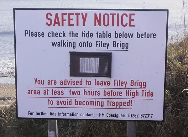 Safety Notice, Please check the tide table below before walking onto Filey Brigg sign on coastal peninsula