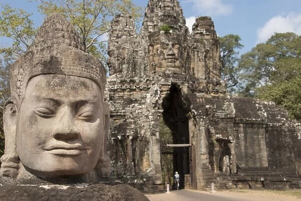 Sculpture of head beside road to gate tower of Khmer temple, South Gate, Angkor Thom, Siem Riep, Cambodia