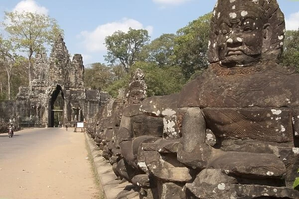 Sculptures of Asuras (demonic monsters) lining road to gate tower of Khmer temple, South Gate, Angkor Thom, Siem Riep