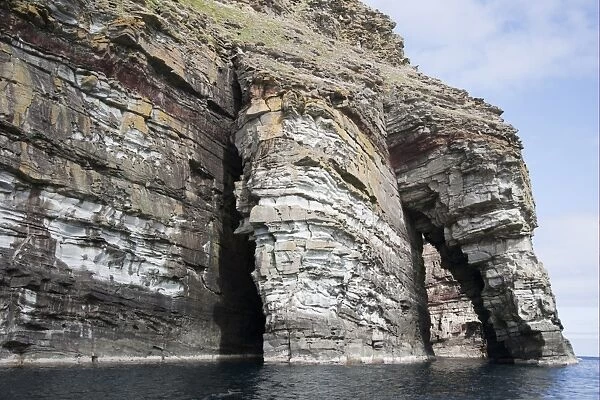 Sea cliff and arch rock formation, Giants Fingers Bressay, Shetland Islands, Scotland, June