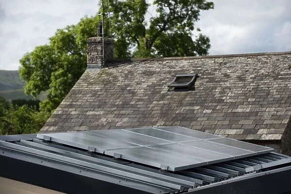 Solar energy panels, fixed on garage to provide electricity for house in rural location, England, july