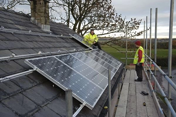 Solar power, photovoltaic panels being fitted on house roof, near Chipping, Lancashire, England, november