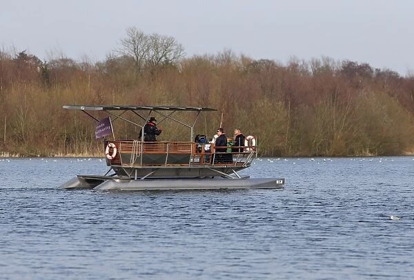 Solar-powered electric boat with tourists on river, Norwich, River Yare, The Broads, Norfolk, England, April