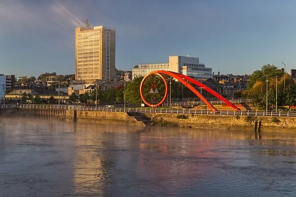 Steel sculpture on city waterfront at dawn, The Wave, River Usk, Newport, South Wales, October