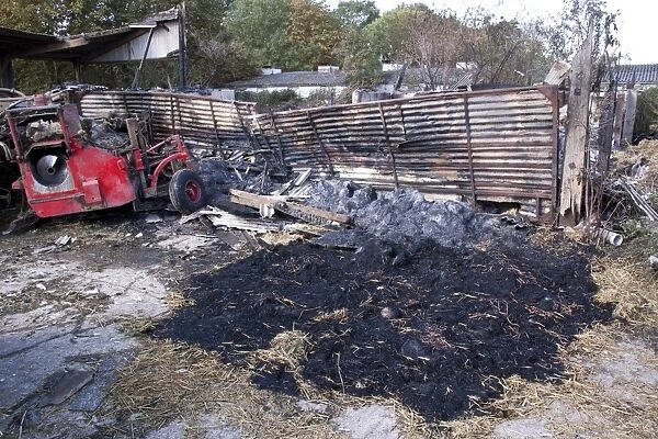 Straw fire in farm yard barn probably coursed by a sugar beat harvesters being parked to closed to the stacked straw
