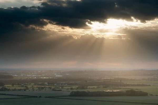 Sunbeams illuminating fields in rural landscape, near Ashford, North Downs, Kent, England, March