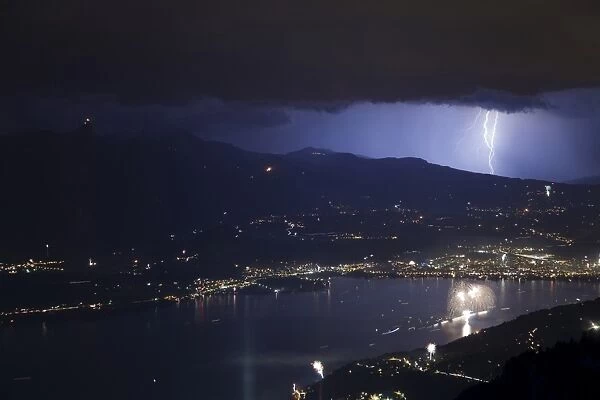 Thunderstorm with lightning and fireworks over city and lake at night, Thun, Lake Thun, Swiss Alps, Bernese Oberland