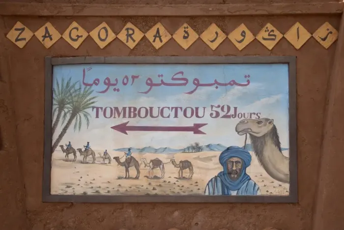 Framed Print : Tombouctou 52 days direction sign in desert town, Zagora, Sahara, Morocco, may Framed Print : Tombouctou 52 days direction sign in desert town, Zagora, Sahara, Morocco, may