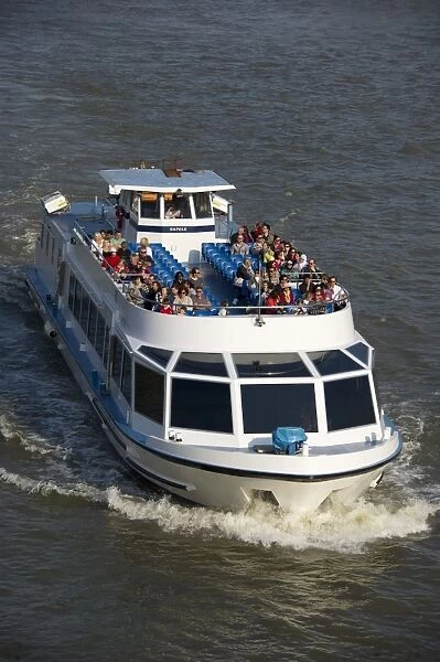 Tourist sightseeing boat on city river, River Thames, London, England, april