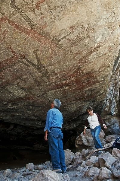 Tourists looking at San Borjitas cave paintings, oldest cave paintings in western hemisphere, circa 7500 years old