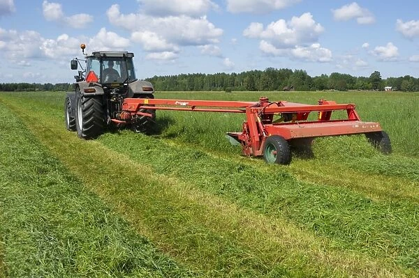Tractor with mower, cutting grass for silage, Sweden, july