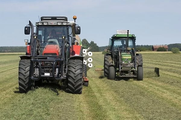 Tractors with rotary rake and baler, turning cut grass and baling silage crop, Sweden