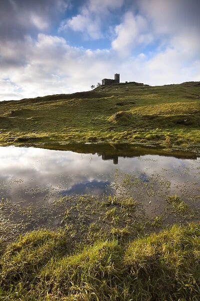 View of 13th century church reflected in large pool created by exceptional winter rain on moorland, Church of St